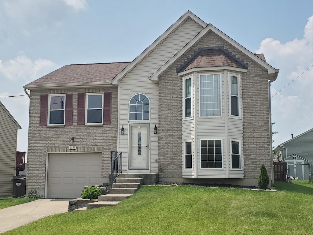 1531 Clovernook Dr, Elsmere, KY 41018 - view of front of house featuring driveway, a front yard, a garage, and brick siding