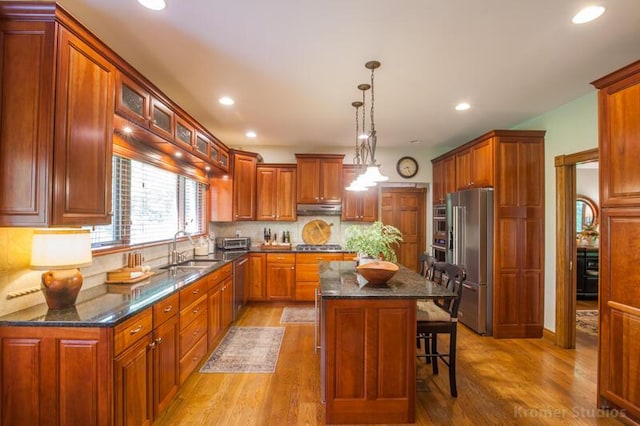 2507 Woodstone Way, Villa Hills, KY 41017 - kitchen featuring stainless steel appliances, light wood-type flooring, under cabinet range hood, a center island, and a breakfast bar area