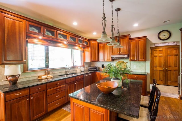 2507 Woodstone Way, Villa Hills, KY 41017 - kitchen featuring under cabinet range hood, dishwasher, a breakfast bar area, hanging light fixtures, and wood finished floors