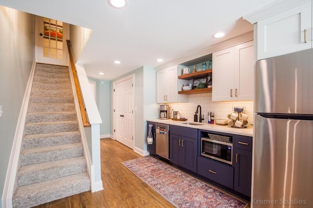 2507 Woodstone Way, Villa Hills, KY 41017 - indoor wet bar with stainless steel appliances, stairs, backsplash, wood finished floors, and recessed lighting
