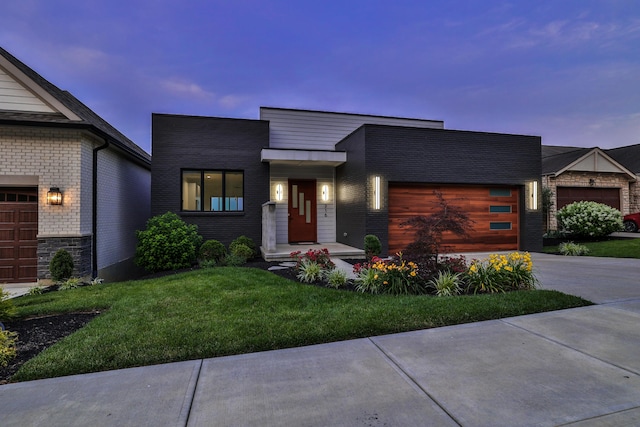 716 Western Ave, Covington, KY 41011 - contemporary house featuring an attached garage, concrete driveway, a yard, and brick siding