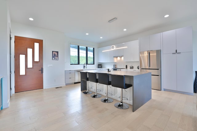 716 Western Ave, Covington, KY 41011 - kitchen featuring stainless steel appliances, modern cabinets, a kitchen island, a breakfast bar, and pendant lighting
