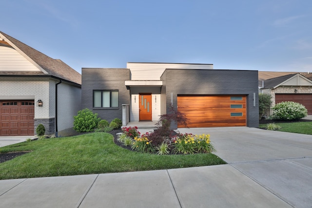 716 Western Ave, Covington, KY 41011 - contemporary home with an attached garage, concrete driveway, a front yard, and brick siding