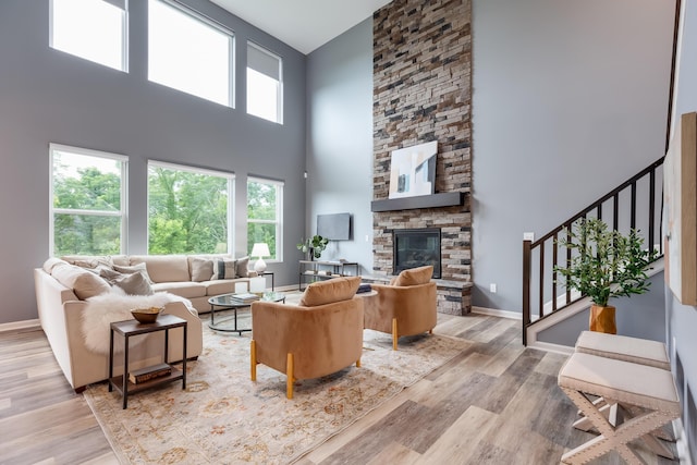 2320 Daybloom Ct, Hebron, KY 41048 - living room featuring a high ceiling, light wood finished floors, stairs, and a stone fireplace