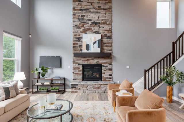 2320 Daybloom Ct, Hebron, KY 41048 - living area featuring a towering ceiling, wood finished floors, stairs, and a stone fireplace