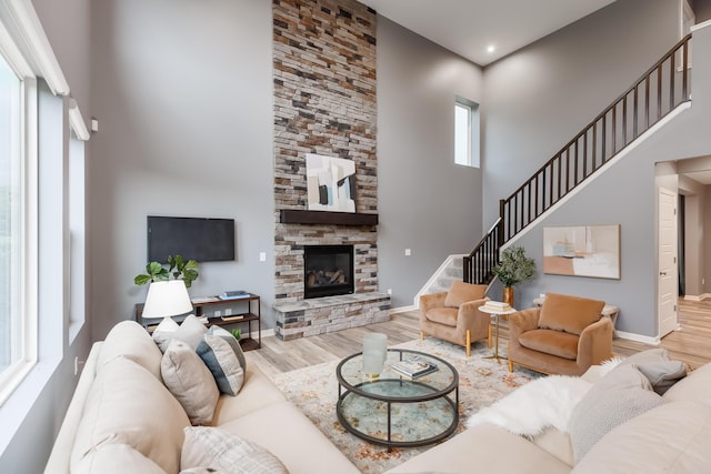 2320 Daybloom Ct, Hebron, KY 41048 - living area featuring a high ceiling, wood finished floors, a stone fireplace, and stairway