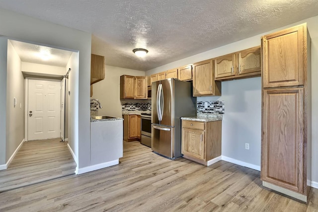 436 Marian Ln Unit 2, Florence, KY 41042 - kitchen with appliances with stainless steel finishes, light wood-type flooring, a textured ceiling, backsplash, and brown cabinetry