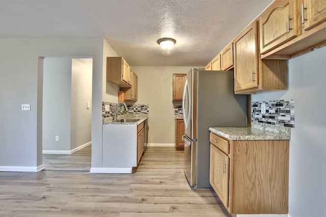 436 Marian Ln Unit 2, Florence, KY 41042 - kitchen featuring light wood-style flooring, backsplash, freestanding refrigerator, a textured ceiling, and light stone countertops