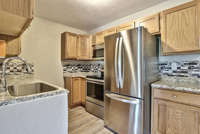436 Marian Ln Unit 2, Florence, KY 41042 - kitchen featuring appliances with stainless steel finishes, decorative backsplash, light wood-type flooring, light stone counters, and a textured ceiling