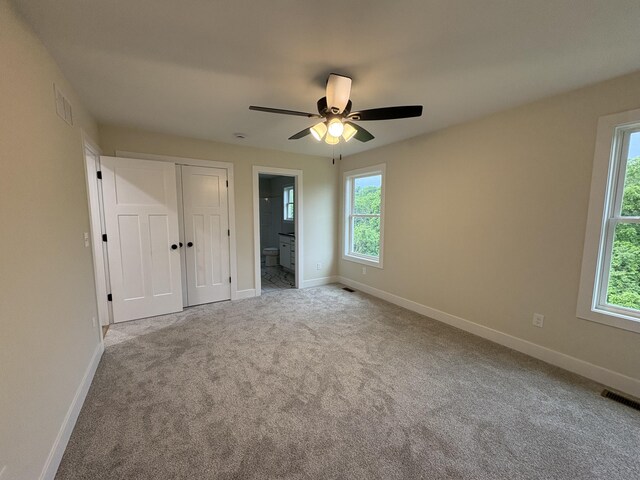 170 Saddlebrook Ln, Dry Ridge, KY 41035 - unfurnished bedroom featuring multiple windows, carpet, ensuite bath, and a ceiling fan