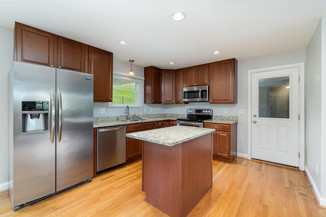 9513 Old Union Rd, Union, KY 41091 - kitchen with appliances with stainless steel finishes, light wood-style flooring, light stone counters, a center island, and recessed lighting