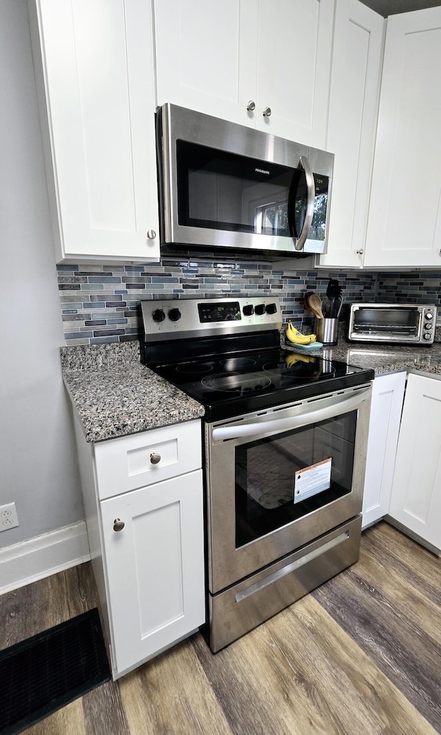 4336 Glenn Ave, Covington, KY 41015 - kitchen with appliances with stainless steel finishes, wood finished floors, decorative backsplash, and white cabinets