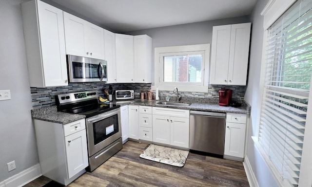 4336 Glenn Ave, Covington, KY 41015 - kitchen featuring stainless steel appliances, dark wood-type flooring, tasteful backsplash, white cabinets, and dark stone countertops