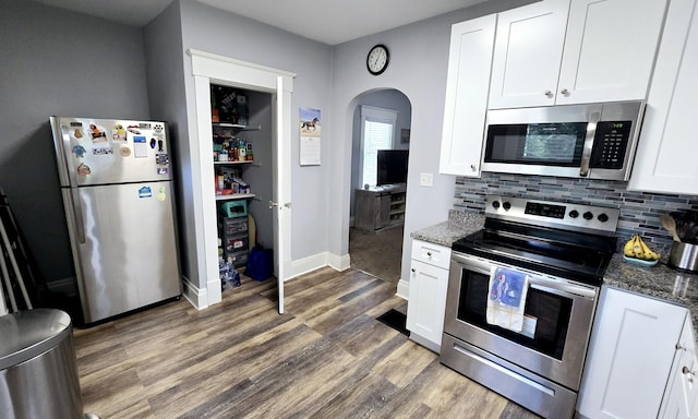4336 Glenn Ave, Covington, KY 41015 - kitchen with appliances with stainless steel finishes, arched walkways, white cabinetry, wood finished floors, and tasteful backsplash