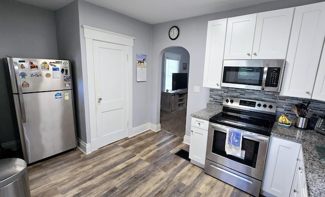 4336 Glenn Ave, Covington, KY 41015 - kitchen with stainless steel appliances, arched walkways, wood finished floors, white cabinets, and tasteful backsplash