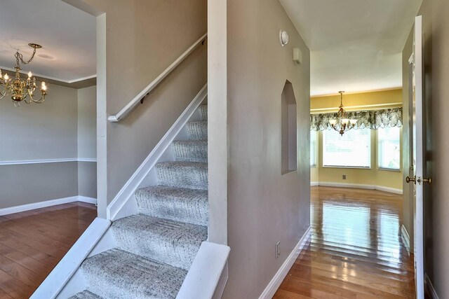 1906 Robins Run, Hebron, KY 41048 - stairway with a chandelier, wood-type flooring, and arched walkways