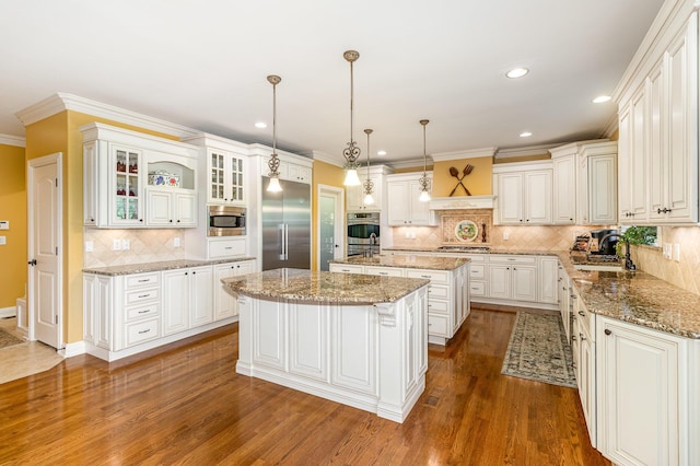1007 Campo Ct, Union, KY 41091 - kitchen featuring built in appliances, a kitchen island with sink, decorative backsplash, crown molding, and dark wood-style floors