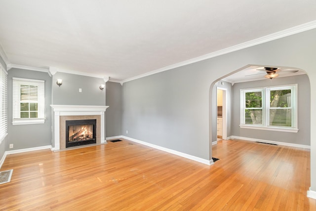 65 Beech Dr, Edgewood, KY 41017 - unfurnished living room featuring a tiled fireplace, light wood-style floors, healthy amount of natural light, arched walkways, and ornamental molding
