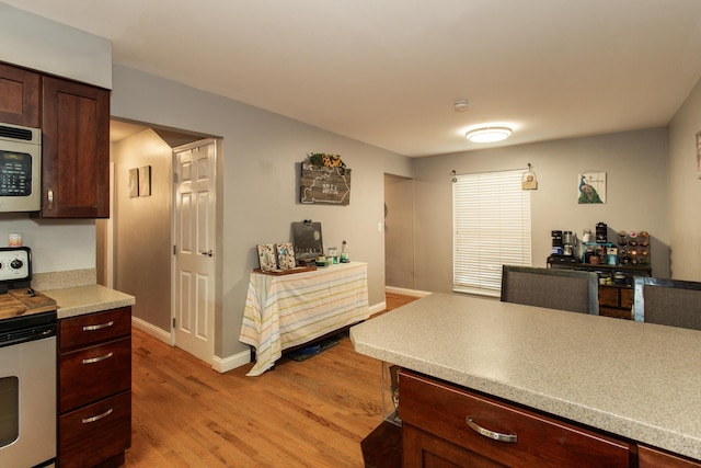 3442 Queensway Dr, Erlanger, KY 41018 - kitchen featuring electric range oven, stainless steel microwave, light wood-style floors, light countertops, and dark brown cabinets