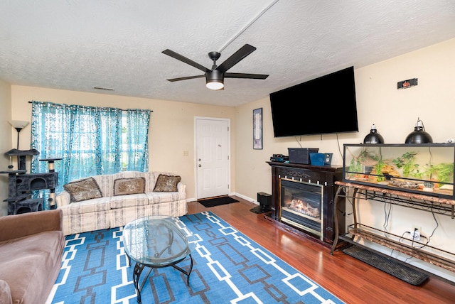 1845 Conrad Ln, Burlington, KY 41005 - living area featuring wood finished floors, a ceiling fan, a glass covered fireplace, and a textured ceiling