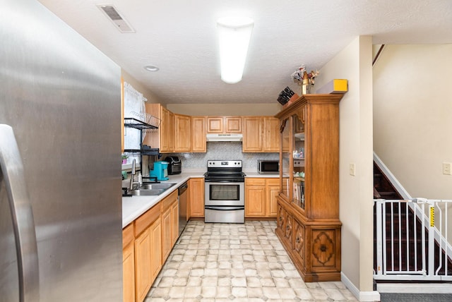 1845 Conrad Ln, Burlington, KY 41005 - kitchen with stainless steel appliances, under cabinet range hood, light countertops, stone finish flooring, and decorative backsplash