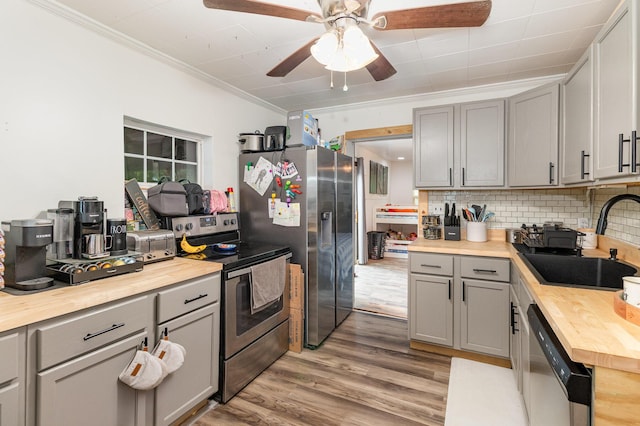 9294 Marshall Rd, Covington, KY 41015 - kitchen featuring wood counters, stainless steel appliances, gray cabinets, ornamental molding, and decorative backsplash
