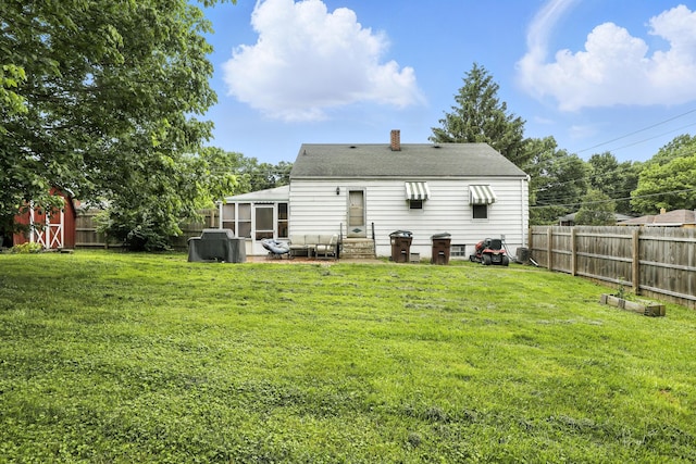 50 Russell St, Florence, KY 41042 - rear view of property with a sunroom, a chimney, a fenced backyard, entry steps, and a storage shed