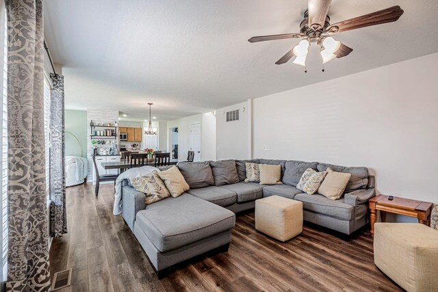 9128 Belvedere Ct, Florence, KY 41042 - living area with dark wood-style flooring, ceiling fan, and a chandelier