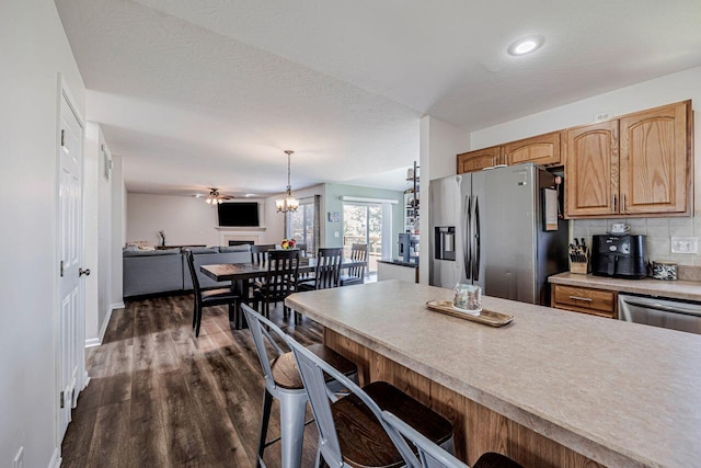 9128 Belvedere Ct, Florence, KY 41042 - kitchen with stainless steel fridge with ice dispenser, a breakfast bar, dark wood-type flooring, light countertops, and backsplash