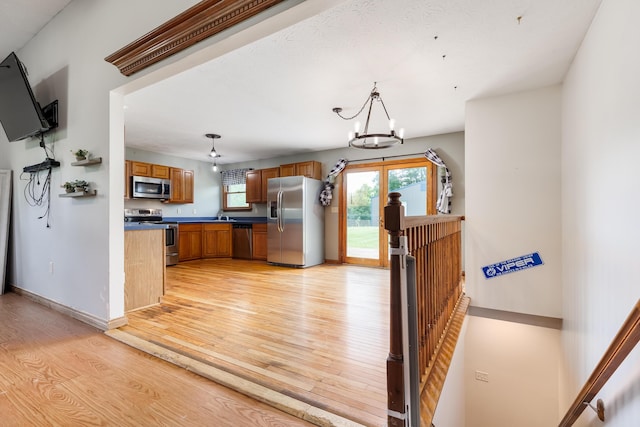 1041 Kidwell Rd, Demossville, KY 41033 - kitchen with stainless steel appliances, light wood finished floors, brown cabinets, a chandelier, and dark countertops