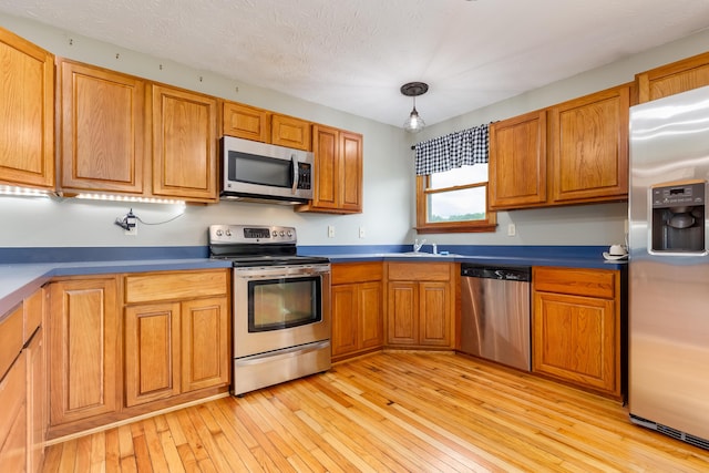 1041 Kidwell Rd, Demossville, KY 41033 - kitchen featuring appliances with stainless steel finishes, brown cabinets, light wood-style flooring, and decorative light fixtures