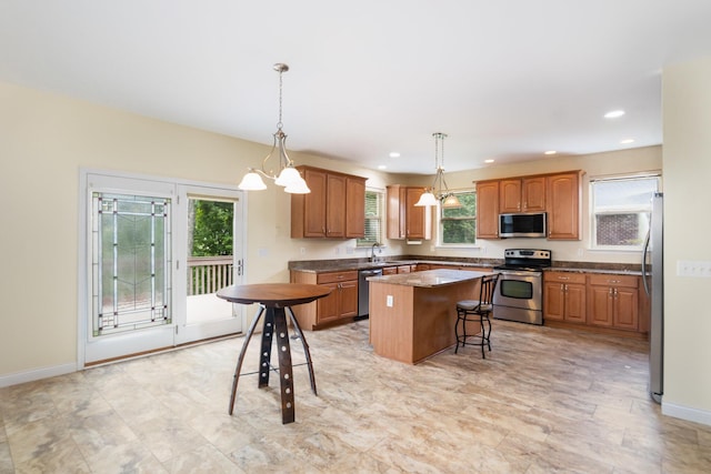 1464 Shirepeak Way, Independence, KY 41051 - kitchen featuring stainless steel appliances, a kitchen island, brown cabinets, hanging light fixtures, and recessed lighting