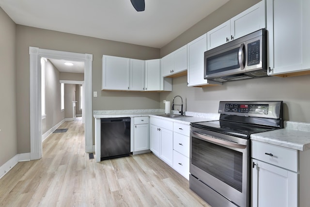 1508 Holman Ave, Covington, KY 41011 - kitchen with appliances with stainless steel finishes, light countertops, light wood-style floors, and white cabinetry