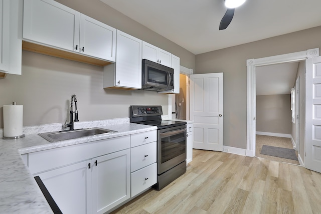 1508 Holman Ave, Covington, KY 41011 - kitchen featuring stainless steel electric stove, white cabinets, light wood-style flooring, a ceiling fan, and light stone countertops
