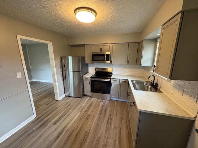 1022 Capitol Ave, Elsmere, KY 41018 - kitchen with stainless steel appliances, gray cabinetry, a textured ceiling, light wood-style flooring, and light countertops