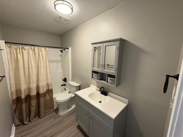 1022 Capitol Ave, Elsmere, KY 41018 - bathroom featuring wood finished floors, vanity, a textured ceiling, and shower / bath combo with shower curtain