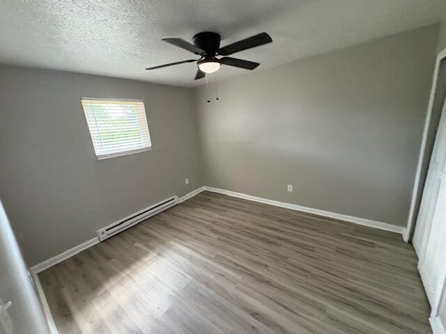 1022 Capitol Ave, Elsmere, KY 41018 - unfurnished room featuring a baseboard heating unit, wood finished floors, a ceiling fan, and a textured ceiling