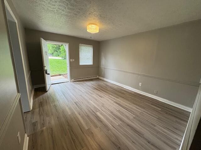 1022 Capitol Ave, Elsmere, KY 41018 - unfurnished dining area with wood finished floors, a baseboard radiator, and a textured ceiling