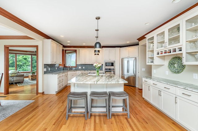 2316 Pinnacle Ct, Hebron, KY 41048 - kitchen with stainless steel appliances, a kitchen island, white cabinets, a breakfast bar area, and crown molding