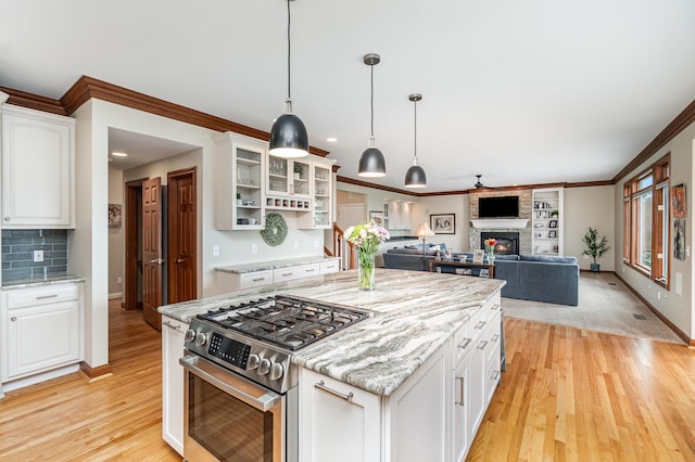 2316 Pinnacle Ct, Hebron, KY 41048 - kitchen with stainless steel gas stove, a fireplace, light wood-style flooring, white cabinets, and glass insert cabinets