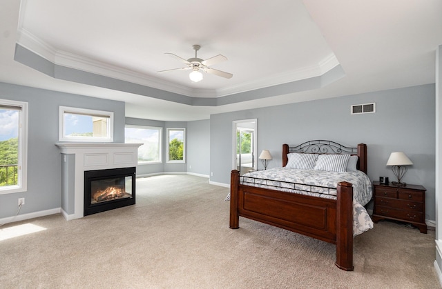 2316 Pinnacle Ct, Hebron, KY 41048 - bedroom featuring a tray ceiling, light carpet, a glass covered fireplace, crown molding, and a ceiling fan