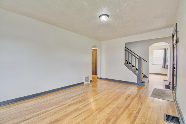 2 Doris Dr, Latonia, KY 41015 - spare room with arched walkways, wood finished floors, a textured ceiling, and stairs