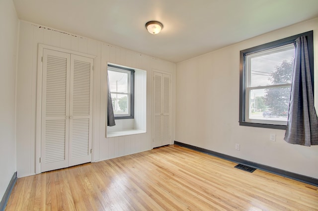 2 Doris Dr, Latonia, KY 41015 - unfurnished bedroom with wood finished floors, multiple windows, and two closets