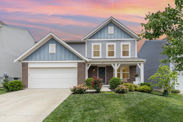 6638 Glencree Ln, Union, KY 41091 - view of front facade with board and batten siding, a lawn, brick siding, a garage, and a porch