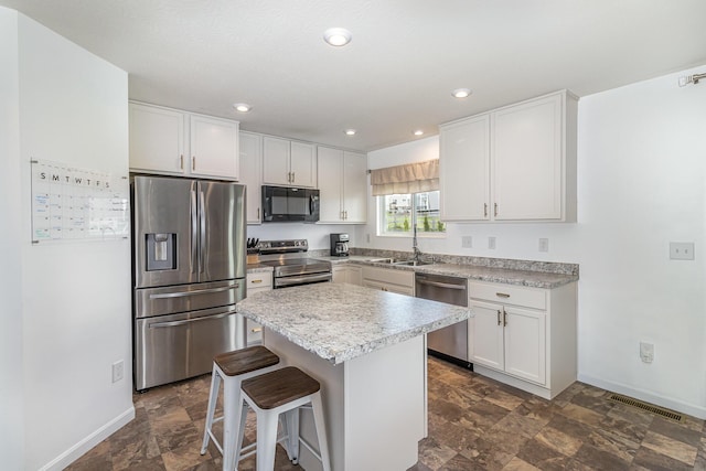 6638 Glencree Ln, Union, KY 41091 - kitchen with appliances with stainless steel finishes, a kitchen bar, stone finish flooring, white cabinetry, and recessed lighting