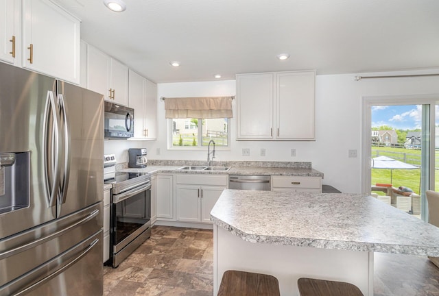 6638 Glencree Ln, Union, KY 41091 - kitchen with appliances with stainless steel finishes, stone finish flooring, plenty of natural light, white cabinetry, and recessed lighting