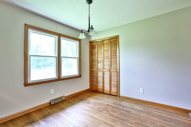 1710 Hilltop Dr, Carrollton, KY 41008 - unfurnished room with a chandelier, light wood-type flooring, and a textured ceiling