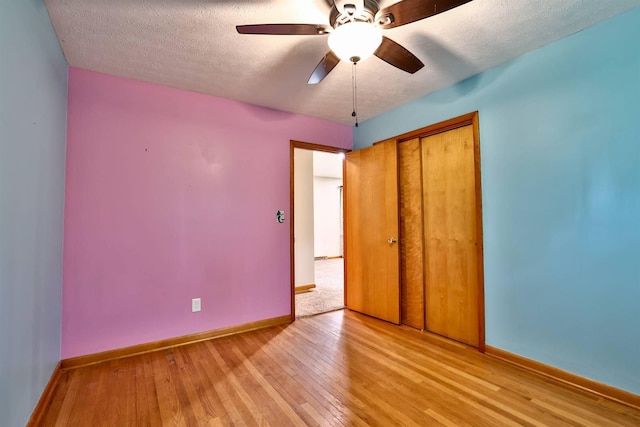 1710 Hilltop Dr, Carrollton, KY 41008 - unfurnished bedroom with light wood finished floors, a closet, a textured ceiling, and ceiling fan