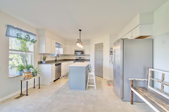 1025 Wakefield Ct, Hebron, KY 41048 - kitchen with appliances with stainless steel finishes, white cabinets, a center island, a breakfast bar, and decorative light fixtures