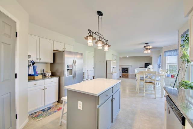 1025 Wakefield Ct, Hebron, KY 41048 - kitchen featuring appliances with stainless steel finishes, a ceiling fan, white cabinetry, pendant lighting, and a center island
